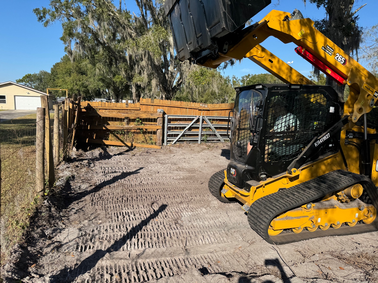 Track loader working along a fence line